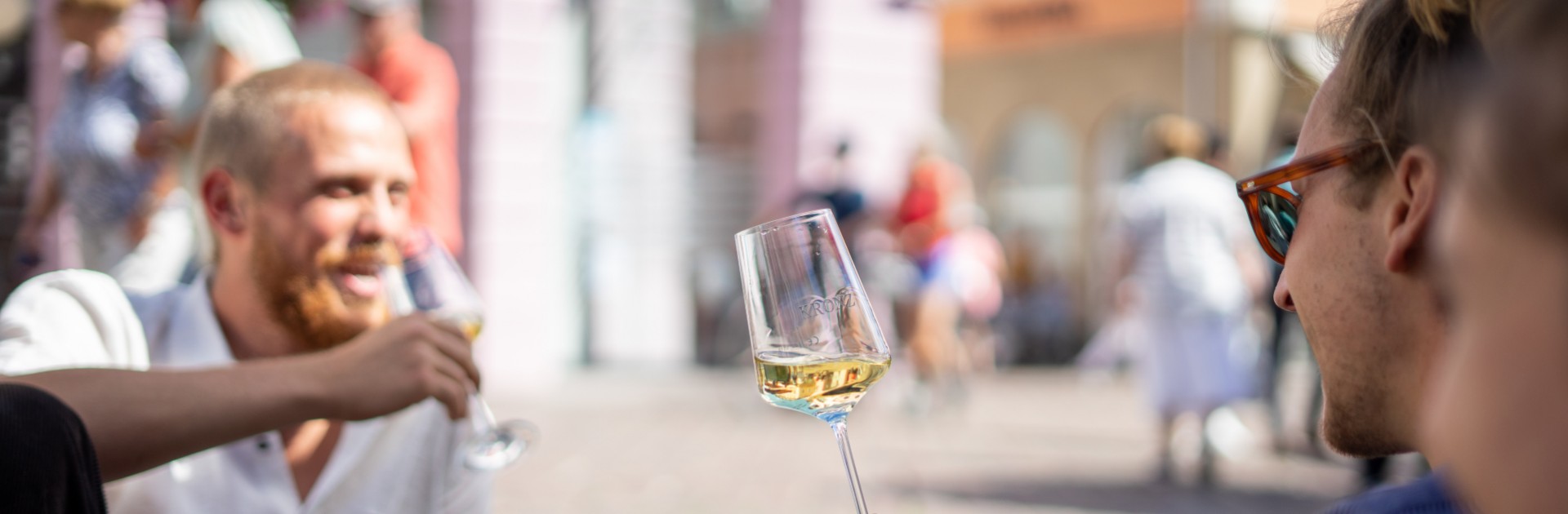 Junge Menschen sitzen zusammen und trinken Weißwein - © Crastulo Media / Trier Tourismus und Marketing GmbH